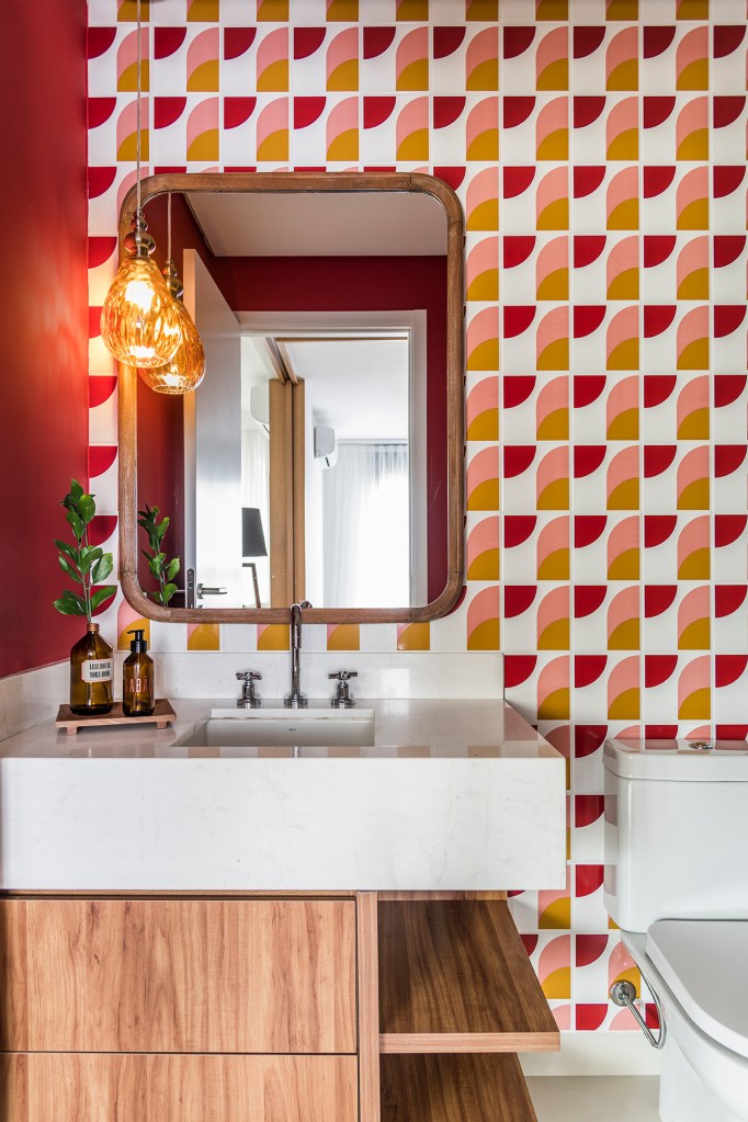 Azulejos estampados e cores trazem personalidade a apê de 100 m². Projeto de Carolina Munhoz. Na foto, lavabo com azulejos estampados e espelho.