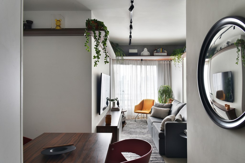 Com apenas 56 m², apartamento ganha décor jovem e descolado. Projeto de Flavia Campos e Sandra Paes. Na foto, sala de estar e jantar com espelho e plantas.