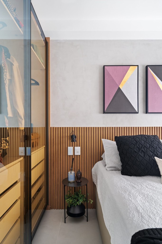 Com circulação otimizada, apê de 49 m² tem tons de verde e madeira. Projeto de Natalia Salla. Na foto, quarto, cabeceira ripada, quadros acima da cama, armário com porta de vidro.