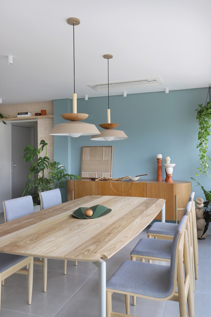 Cozinha verde e espaço para a cachorrinha marcam apê de casal gamer. Projeto de Studio 92 Arquitetura. Na foto. sala de jantar com buffet e mesa de madeira.