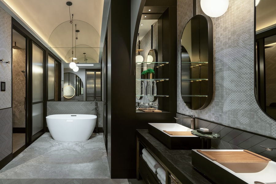 Hotel em Singapura destaca-se pelos grandes jardins verticais tropicais. Na foto, banheiro com espelhos, metais pretos e banheira solta.