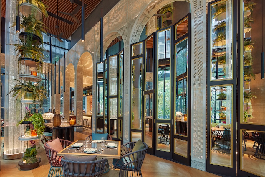 Hotel em Singapura destaca-se pelos grandes jardins verticais tropicais. Na foto, restaurante com pé-direito alto e portas com espelhos