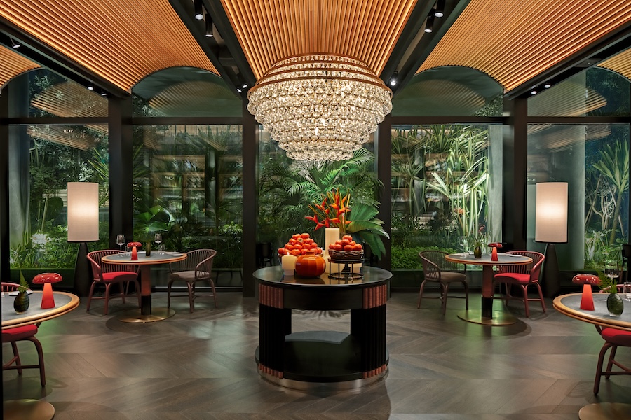 Hotel em Singapura destaca-se pelos grandes jardins verticais tropicais. Na foto, hall com lustre de cristal e janela para jardim.