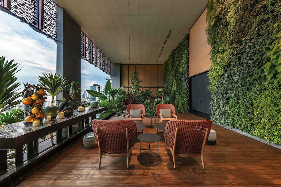 Hotel em Singapura destaca-se pelos grandes jardins verticais tropicais. Na foto, varanda com poltronas, jardim vertical.
