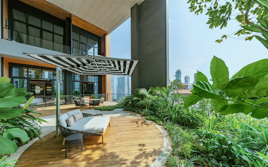 Hotel em Singapura destaca-se pelos grandes jardins verticais tropicais. Na foto, varanda com jardim tropical, ombrelone.