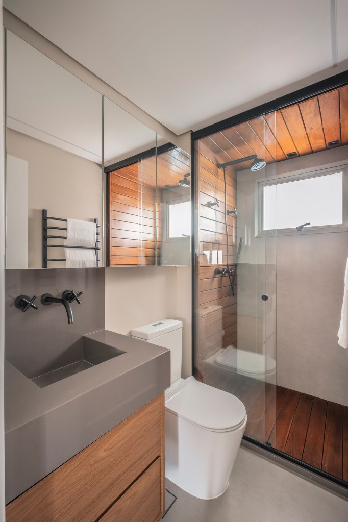 Mix de elementos naturais e industriais marca décor deste apê de 67 m². Projeto de Box 14 Arquitetura. Na foto, banheiro com revestimentos com textura de madeira.