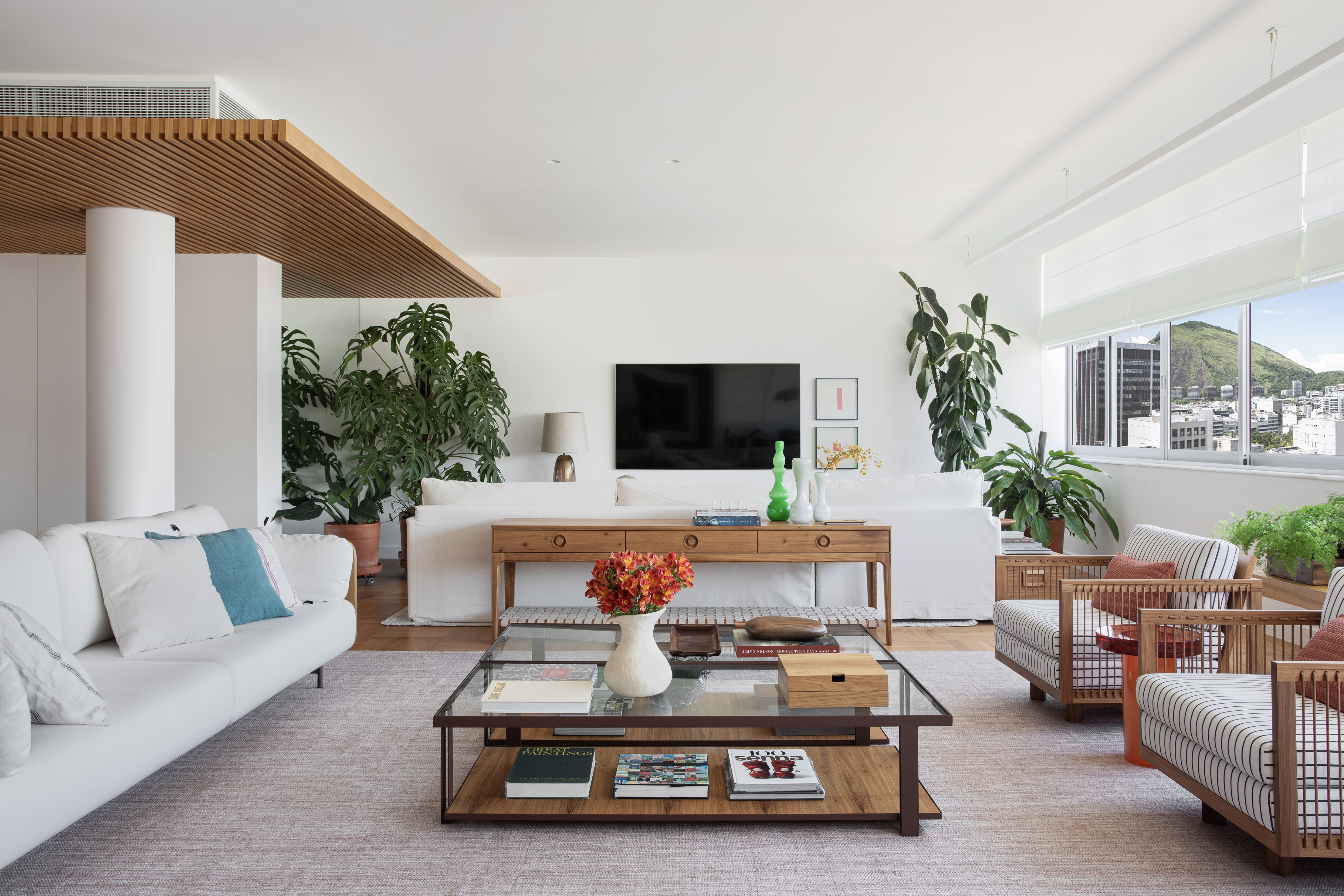 Reforma restaura piso de peroba e cria duas suítes em apê de 360 m². Projeto de Escala Arquitetura. Na foto, sala de estar, tapete, mesa de centro com tampo de vidro.