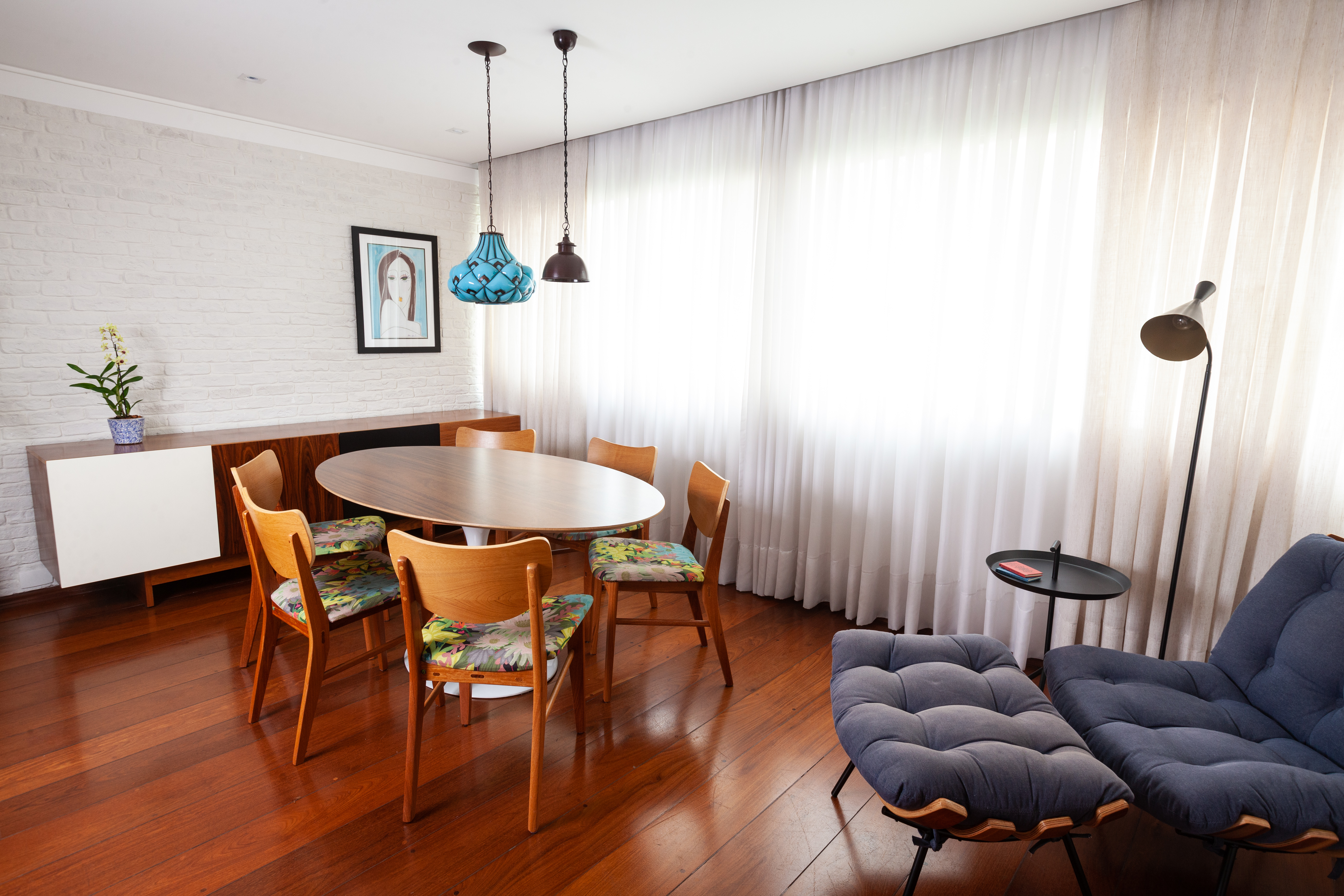 Sem quebra-quebra, apê ganha nova atmosfera com móveis e texturas. Projeto de Abrazo Interiores. Na foto, sala de estar, cortina branca, piso de madeira, mesa redonda.