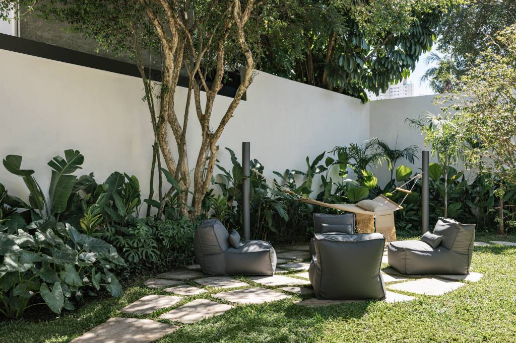 vao-9-m-integra-casa-350-m2-jardim-alexandre-dal-fabbro-credito-fran-parente (1) Vão de 9 m integra esta casa de 350 m² ao jardim. Projeto de Alexandre Dal Fabbro. Na foto, jardim com rede, sofá e fogueira.