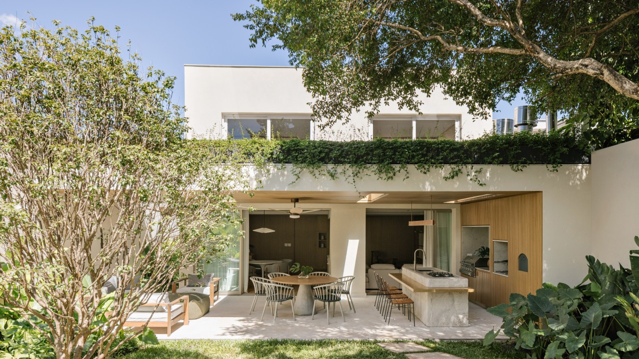 Vão de 9 m integra esta casa de 350 m² ao jardim. Projeto de Alexandre Dal Fabbro. Na foto, varanda com churrasqueira e telhado verde.