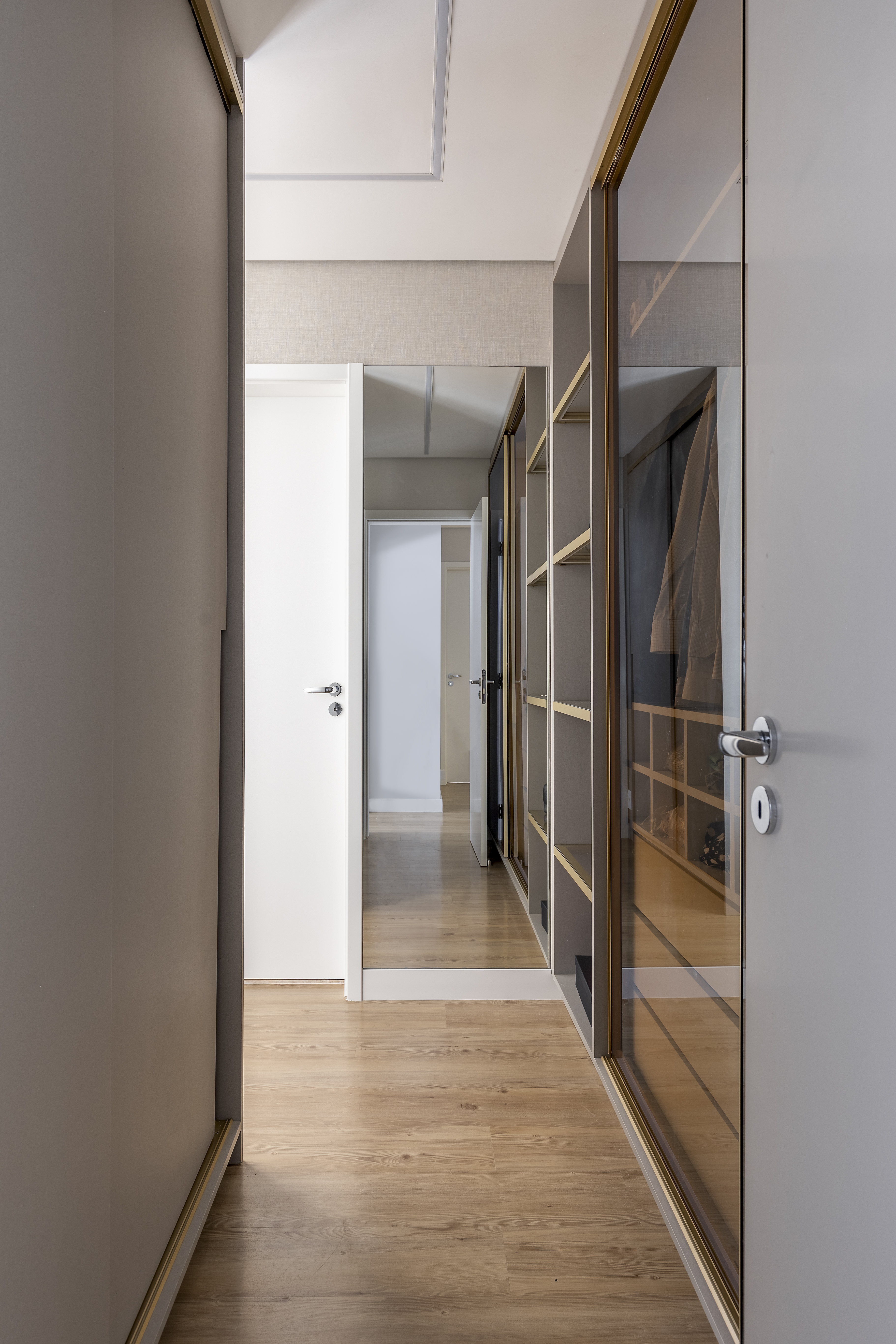 Varanda de apê tem dois espaços: um gourmet e outro de estar. Projeto de Blaia e Moura. Na foto, closet com armários com portas espelhadas.