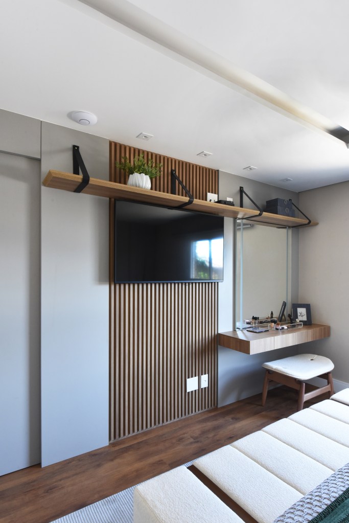 Varanda de estar gourmet é destaque em apartamento de 204 m². Projeto de Rosangela Pena. Na foto, painel com tv, quarto, penteadeira.