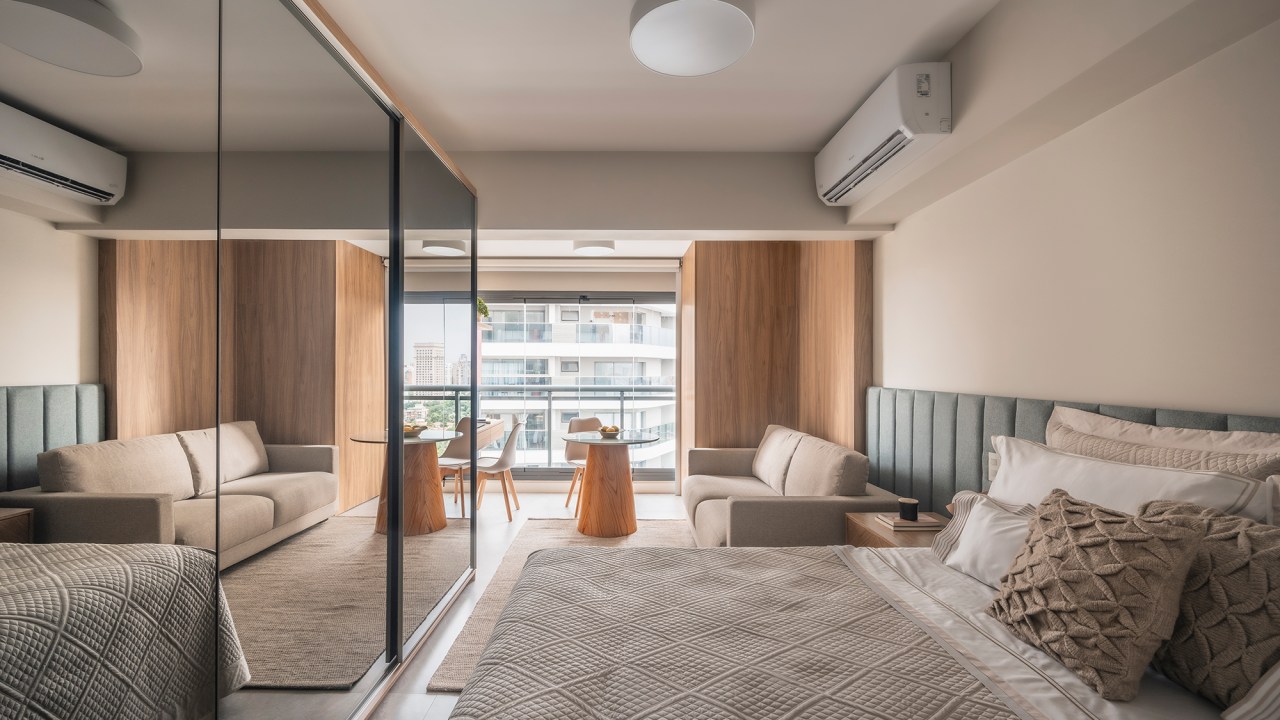 Varanda envidraçada otimiza a área de apartamento de apenas 24 m². Projeto de Gabriela Campanha. Na foto, sala, quarto e varanda integrados.
