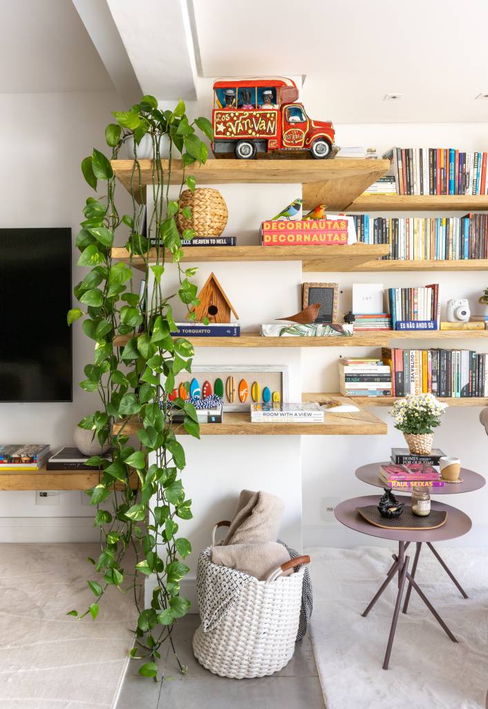 Apartamento em São Paulo tem decoração leve com livros e plantas. Projeto de Sou Arquitetura. Na foto, prateleira com livros e acessórios, jiboia.