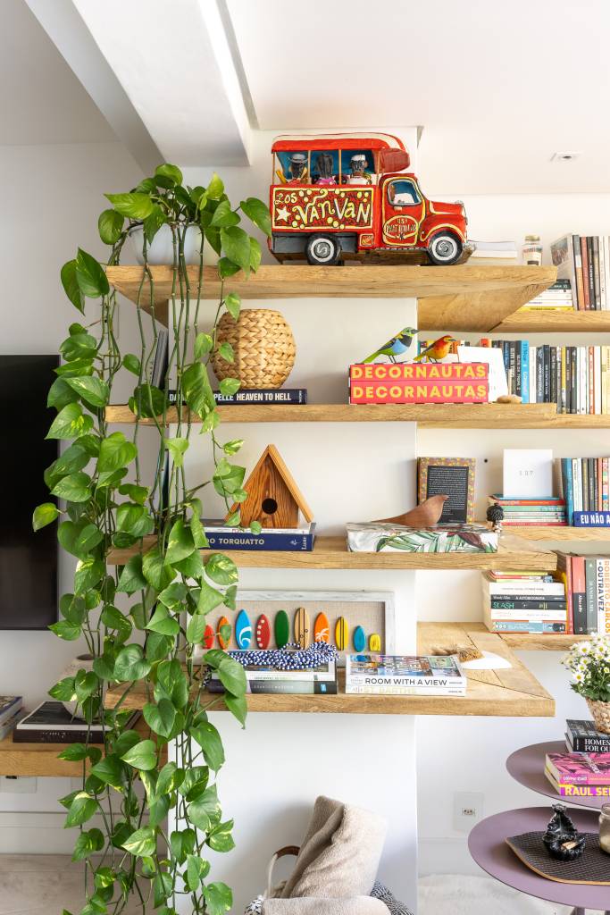 Apartamento em São Paulo tem decoração leve com livros e plantas. Projeto de Sou Arquitetura. Na foto, prateleira com livros e acessórios, jiboia.