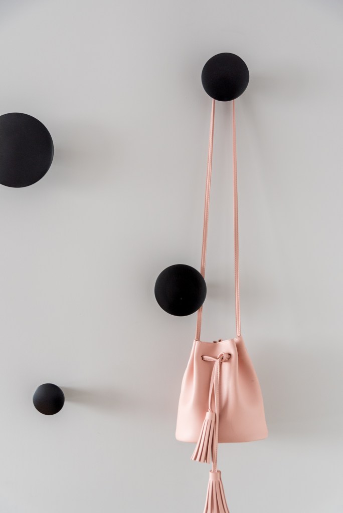 Cabideiro e sapateira: o conjunto que traz praticidade e beleza ao hall. Projeto de Spaço Interior. Na foto, ganchos pretos, bolsa rosa.