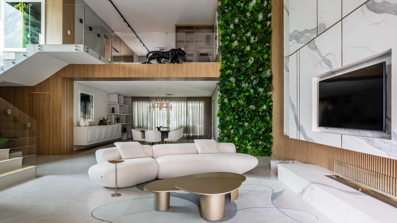 Casa ganha funcionalidade e beleza com lareira ecológica e jardim vertical. Projeto de Daniel Santana. Na foto, sala, painel de mármore, sofá orgânico branco.