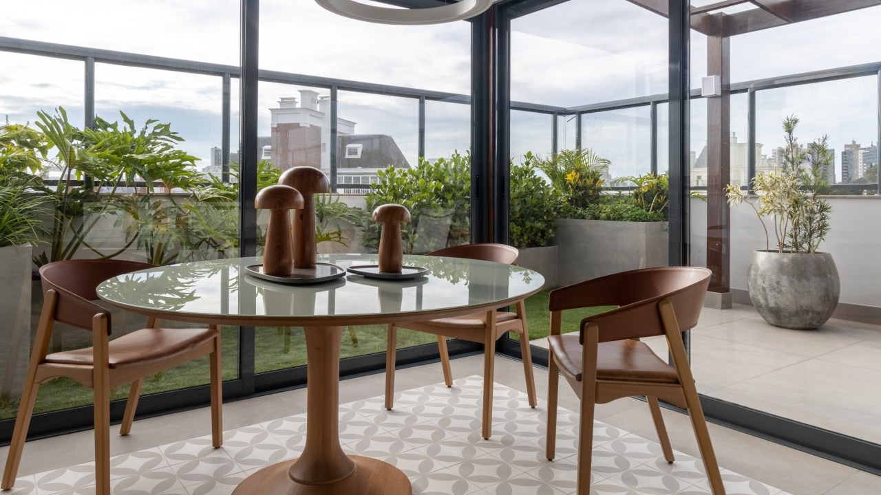 Cozinha integrada ao jardim é o coração deste apartamento de 282 m². Projeto Estudio Elmor. Na foto, cozinhac om piso estampado e mesa redonda. Vista para o jardim.