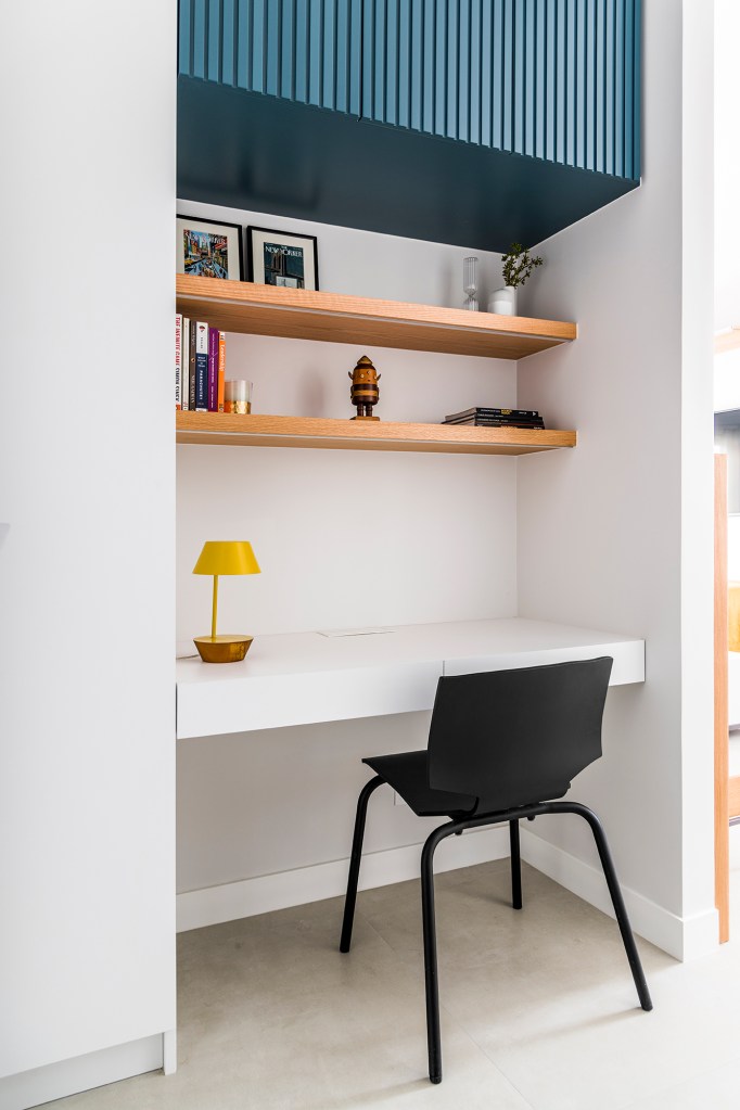 Dois escritórios e ampla área de receber caracterizam apê de 175 m². Projeto de Juliana Casadei. Na foto, home office com armário ripado e prateleiras.