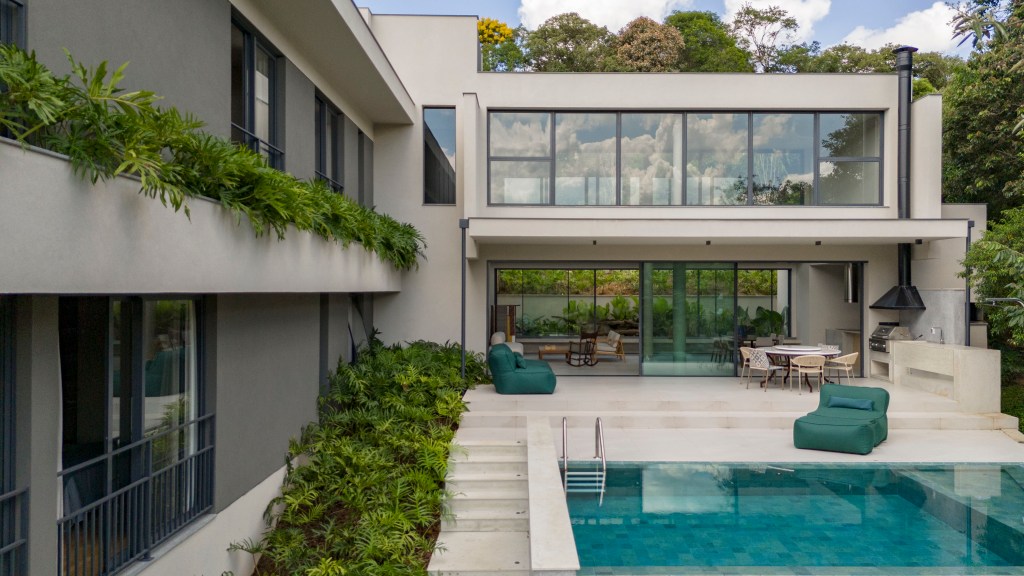 Inspirada no Japão, casa de 524 m² tira proveito da declividade do terreno. Projeto de Cité Arquitetura. Na foto, fachada da casa com jardim e piscina.
