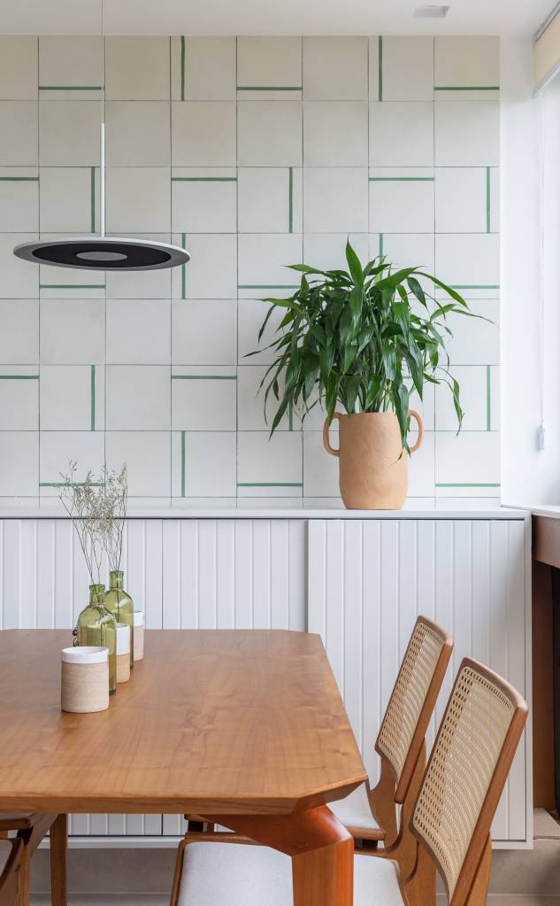 Laca na decoração: veja vantagens, mitos e como cuidar de peças laqueadas. Projeto de Memoá Arquitetos. Na foto, varanda, buffet, mesa de jantar, planta, parede de azulejos.