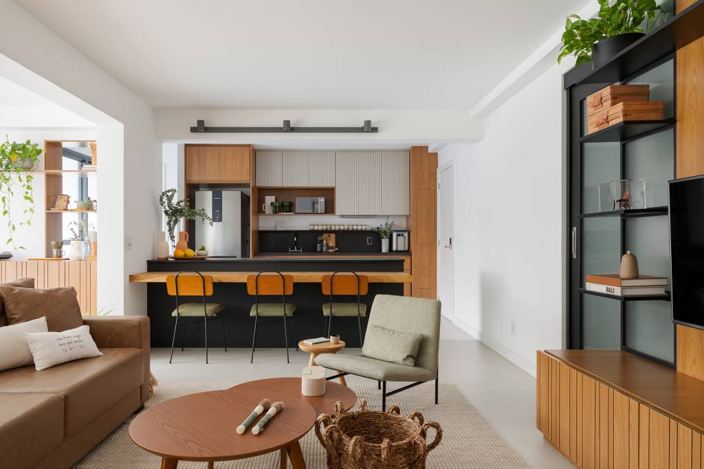 madeira-conforto-praticidade-apartamento-116-m2-studio-canto-credito-julia-novoa (13) Madeira, conforto e praticidade caracterizam este apartamento de 116 m². Projeto de Studio Canto. Na foto, cozinha com balcão preto e bancada de madeira rústica.