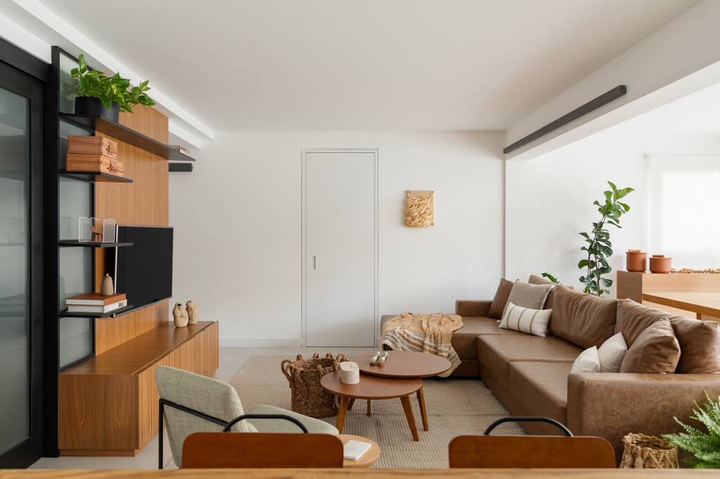 madeira-conforto-praticidade-apartamento-116-m2-studio-canto-credito-julia-novoa (20) Madeira, conforto e praticidade caracterizam este apartamento de 116 m². Projeto de Studio Canto. Na foto, sala com painel de TV, mesa de centro, tapete e plantas.