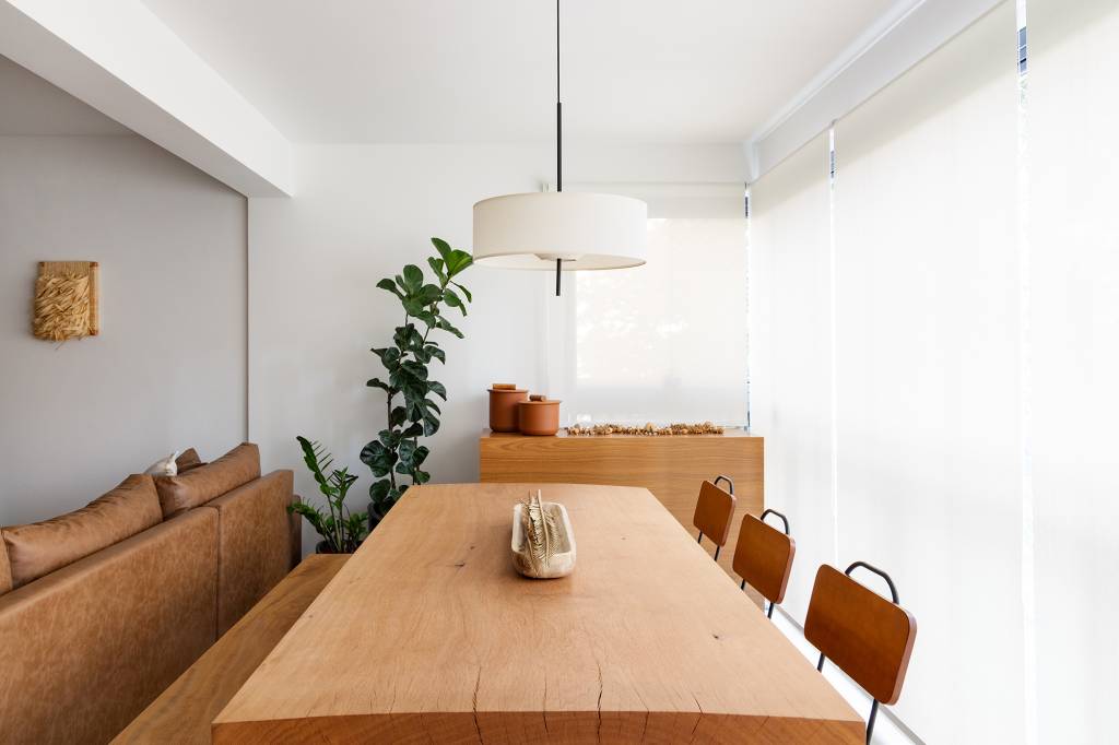 madeira-conforto-praticidade-apartamento-116-m2-studio-canto-credito-julia-novoa (21) Madeira, conforto e praticidade caracterizam este apartamento de 116 m². Projeto de Studio Canto. Na foto, varanda com mesa de jantar, cortina e pendente.