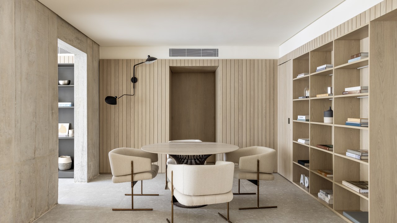 Marcenaria setoriza e decora apartamento de 156 m². Projeto de Alexandre Dal Fabbro. Na foto, sala de jantar com mesa redonda e estantes.