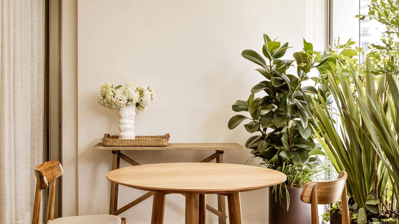 Mármore e madeira marcam showroom minimalista de joalheira. Projeto de Marina Salles Arquitetura. Na foto, varanda, mesa redonda, plantas.