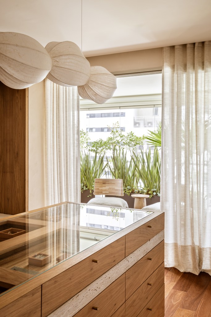 Mármore e madeira marcam showroom minimalista de joalheira. Projeto de Marina Salles Arquitetura. Na foto, vitrina, janela para varanda, luminária.