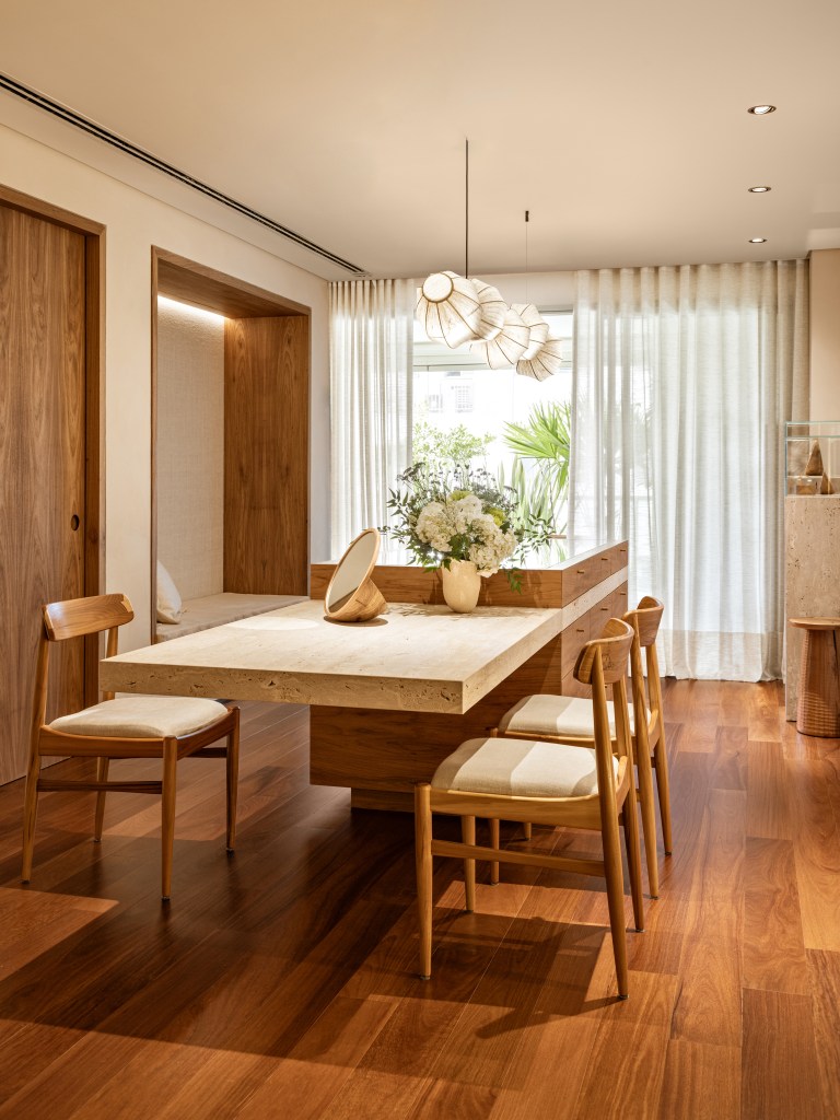 Mármore e madeira marcam showroom minimalista de joalheira. Projeto de Marina Salles Arquitetura. Na foto, sala, piso de madeira, mesa, cadeiras.