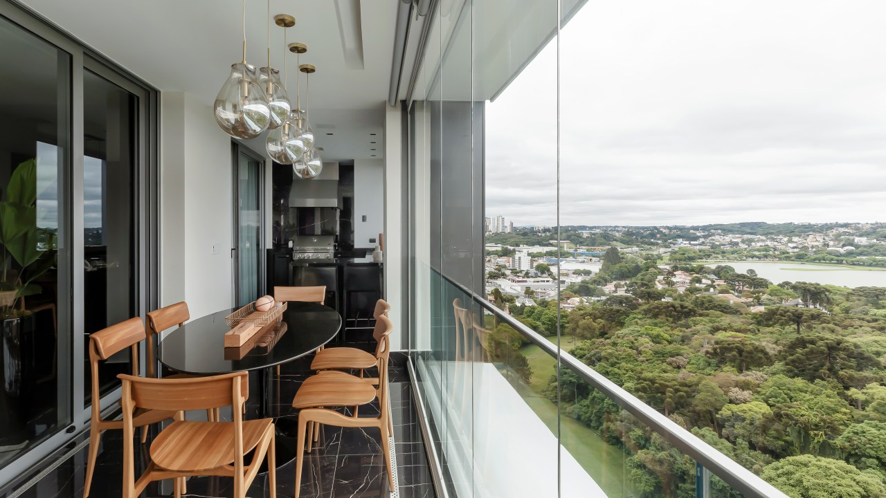 Móveis soltos e paleta sóbria deixam apê de 190 m² atemporal e elegante. Projeto de NK Arquitetura. Na foto, varanda fechada com vidro com área gourmet.