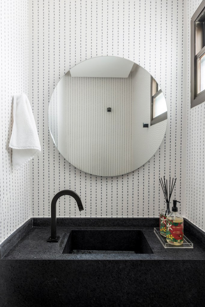 Papel de parede de formiga traz irreverência a este apê de 153 m². Projeto Next Arquitetos. Na foto, lavabo com papel de parede de formiga e espelho redondo.