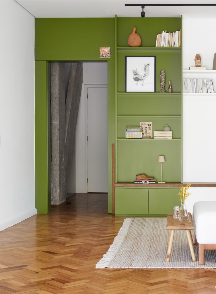 Porta de serralheria vira luminária pendente em cobertura com parrilheira. Projeto de Hugo Rapizo Arquitetura. Na foto, piso de madeira, parede verde e branca.