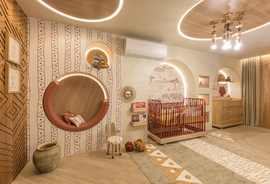 Quarto de bebê de 25 m² homenageia a rainha de Angola, Njinga. Projeto de Kesley Santiago para a CASACOR São Paulo 2024. Na foto, quarto com berço, sofá, parede estampada e tapete.