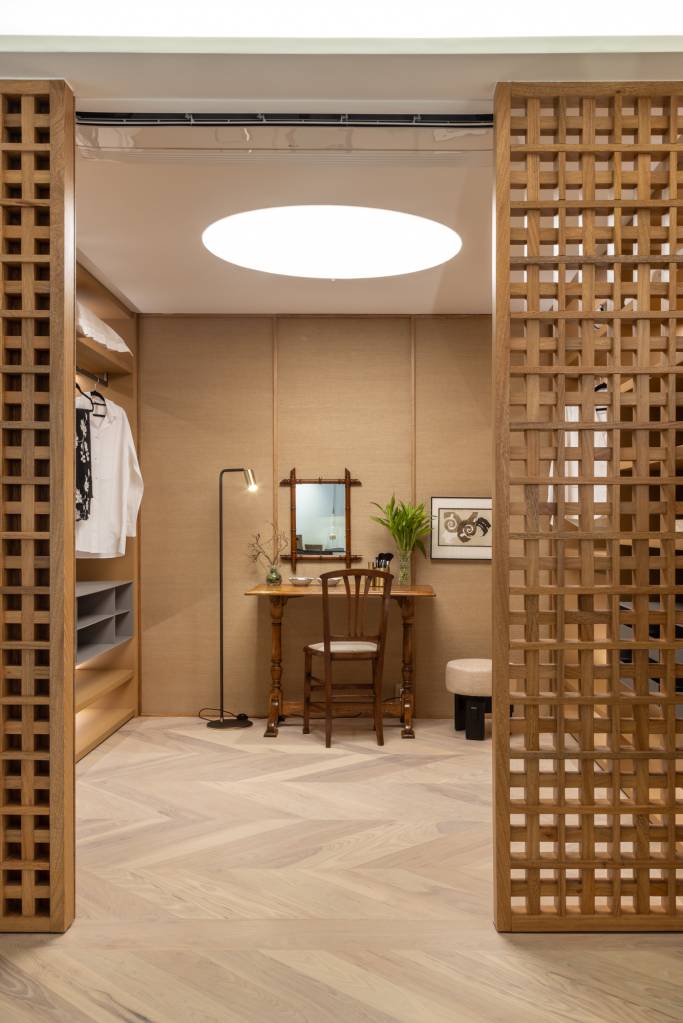 Quarto com conforto de hotel é inspirado na cultura japonesa. Projeto de Migs Arquitetura para a CASACOR SP 2024. Na foto. closet com parede de muxarabi e penteadeira.