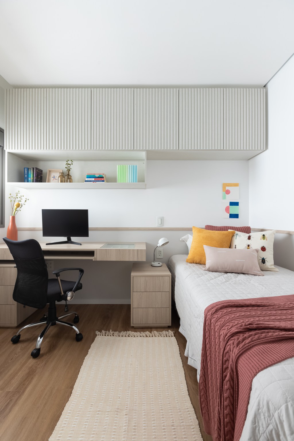 Aconchego e praticidade: apartamento de 126m² possui porcelanato acinzentado neutro e vinílico. Projeto do Estúdio Bena. Na foto, quarto infantil com detalhes coloridos