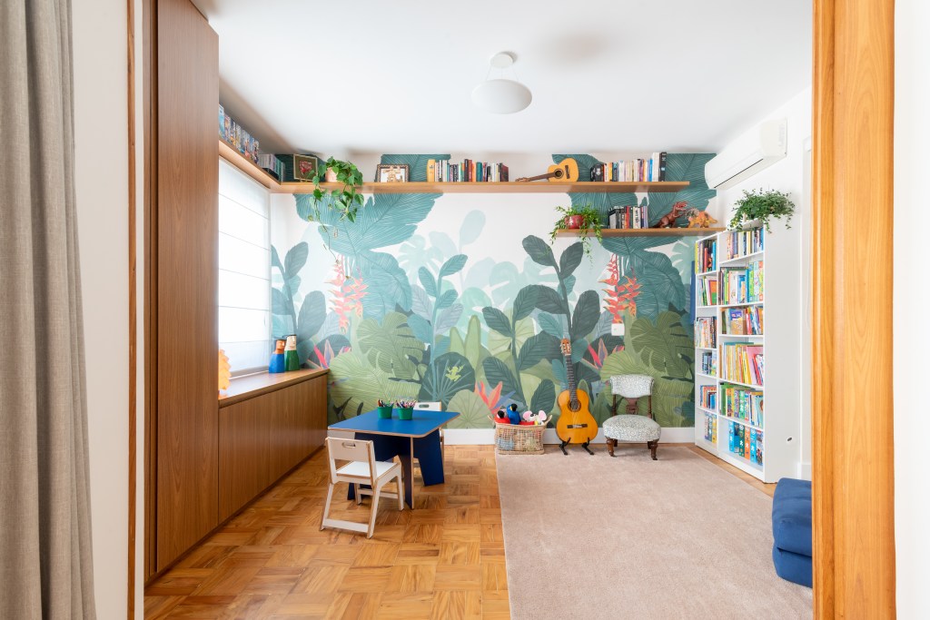 Apartamento térreo ganha brinquedoteca com papel de parede tropical. Projeto de Abrazo Interiores. Na foto, brinquedoteca, piso de madeira, tapete bege.