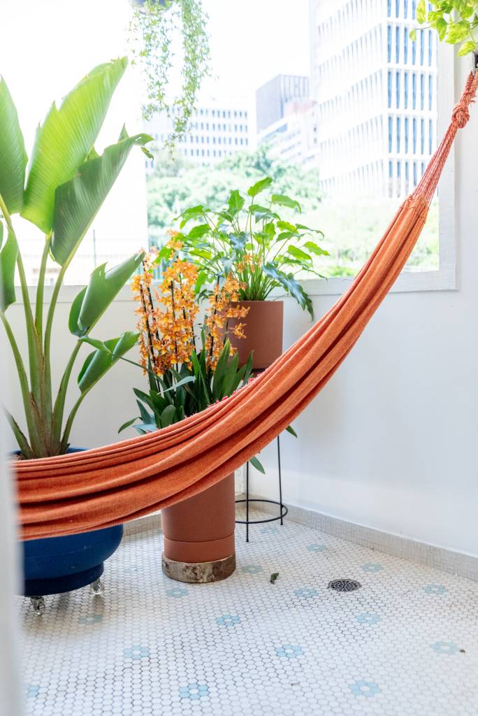 Apartamento térreo ganha brinquedoteca com papel de parede tropical. Projeto de Abrazo Interiores. Na foto, varanda, rede, plantas.