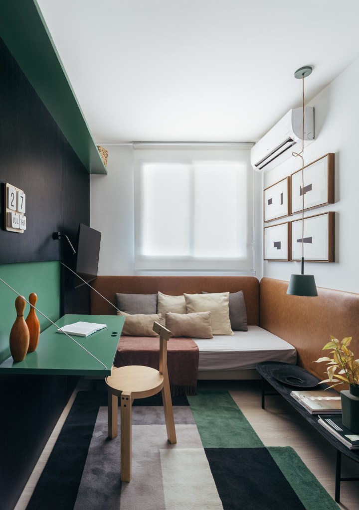 Apê de 73 m² tem marcenaria ebanizada e piso de porcelanato preto. Projeto de Studio Leandro Neves. Na foto, quarto, home office, mesa retrátil verde, tapete colorido.