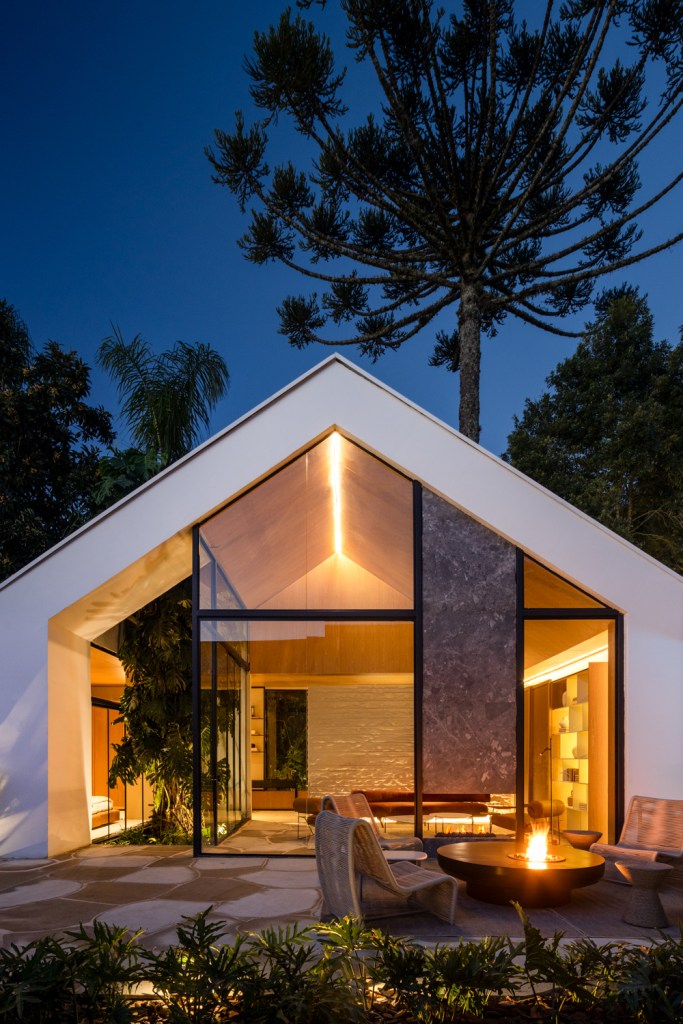 Cabana com telhado de duas águas tem décor escandinavo e lareira. Projeto de GRIFF Arquitetura para a CASACOR Paraná 2024. Na foto, fachada externa.