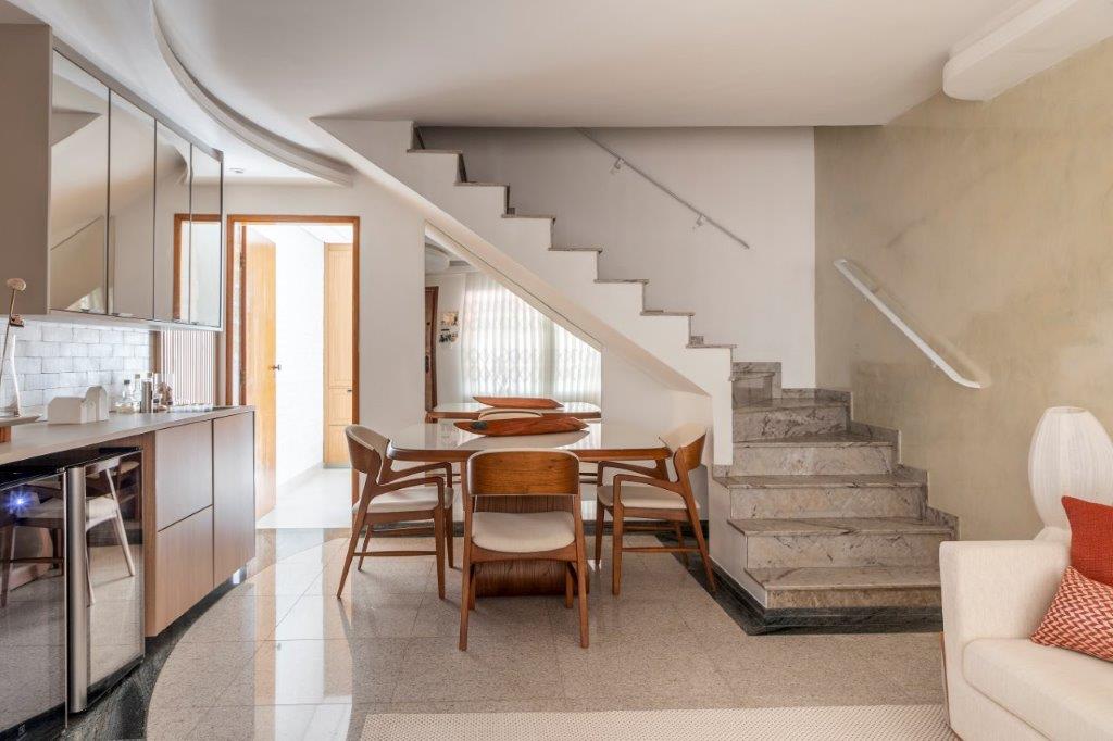Casa de 146 m² ganha cozinha verde clara e área externa com churrasqueira. Projeto de Camila Bischoff. Na foto, escada, mesa de jantar embaixo da escada.