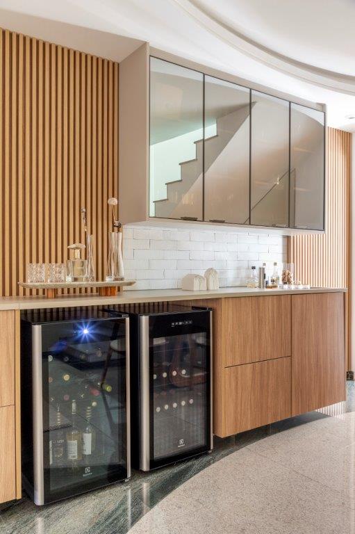 Casa de 146 m² ganha cozinha verde clara e área externa com churrasqueira. Projeto de Camila Bischoff. Na foto, painel ripado, tv, adega, buffet.