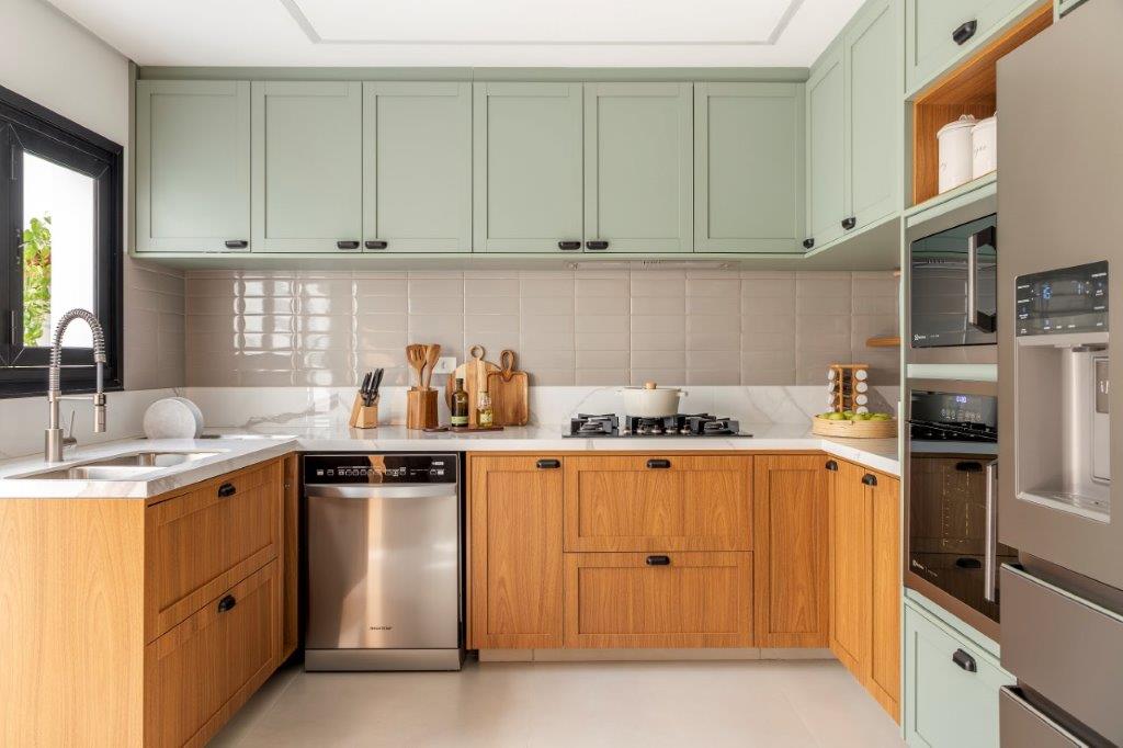Casa de 146 m² ganha cozinha verde clara e área externa com churrasqueira. Projeto de Camila Bischoff. Na foto, cozinha em estilo provençal, armários verdes, bancada branca, backsplash de tijolinhos.
