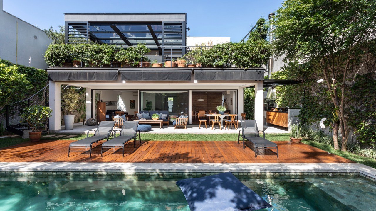Casa com 400 m² possui suíte com terraço privativo. Projeto de Carolina Gava. Na foto, área externa com piscina