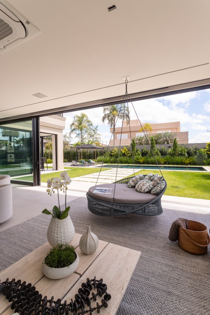 Casa de 900 m² tem jardim com jabuticabeira no living. Projeto de Patricia Penna Arquitetura & Design. Na foto, sala de estar com vista para jardim