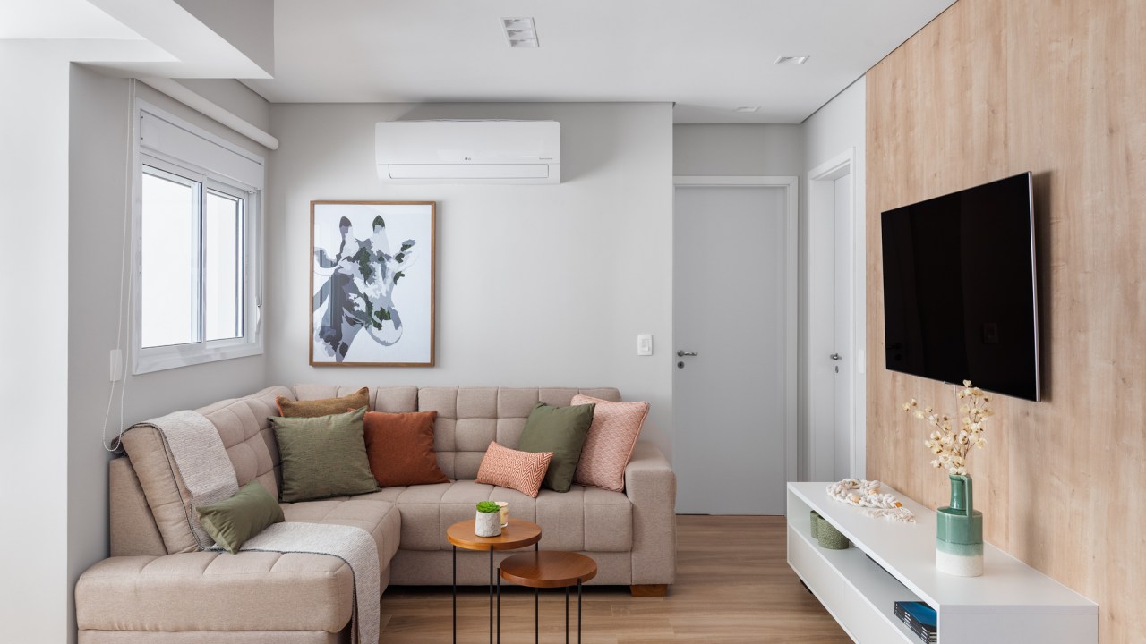 8 ideias para deixar sua sala de estar mais aconchegante. Projeto de Duno Arquitetura. Na foto, sofá L, tv, ar condicionado.