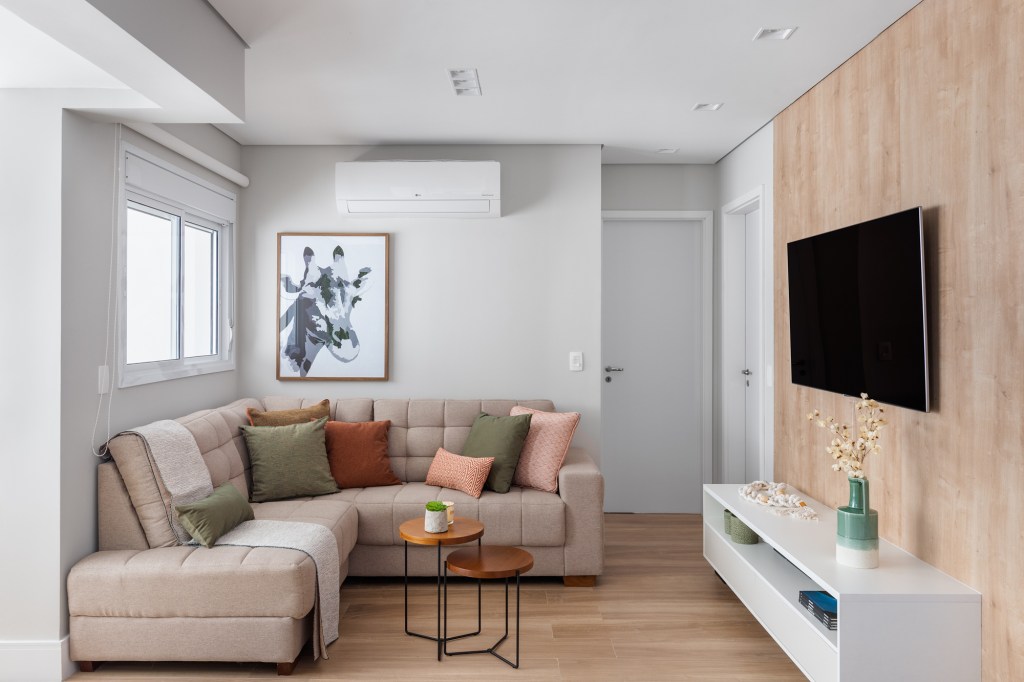 8 ideias para deixar sua sala de estar mais aconchegante. Projeto de Duno Arquitetura. Na foto, sofá L, tv, ar condicionado.