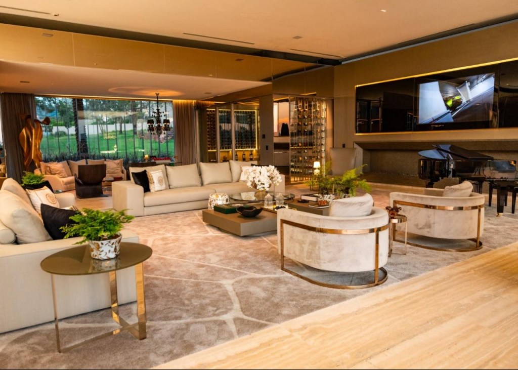 Luxo em formato U: mansão de 3 mil m² mostra sofisticação e tecnologia. Projeto da Mapa Group. Na foto, sala de estar com toques em dourado e verde.